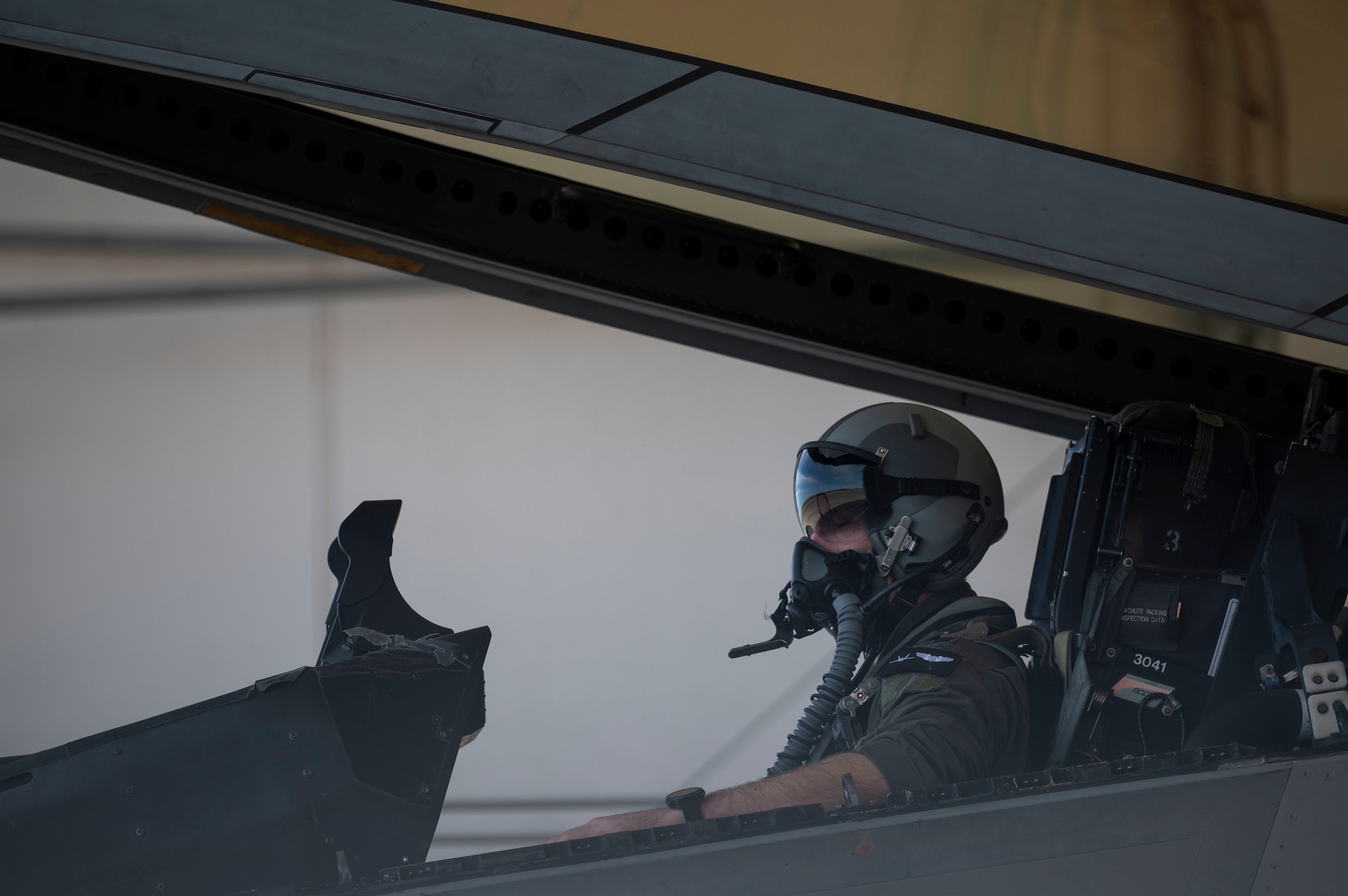 A pilot sits in the cockpit of an F-22 Raptor