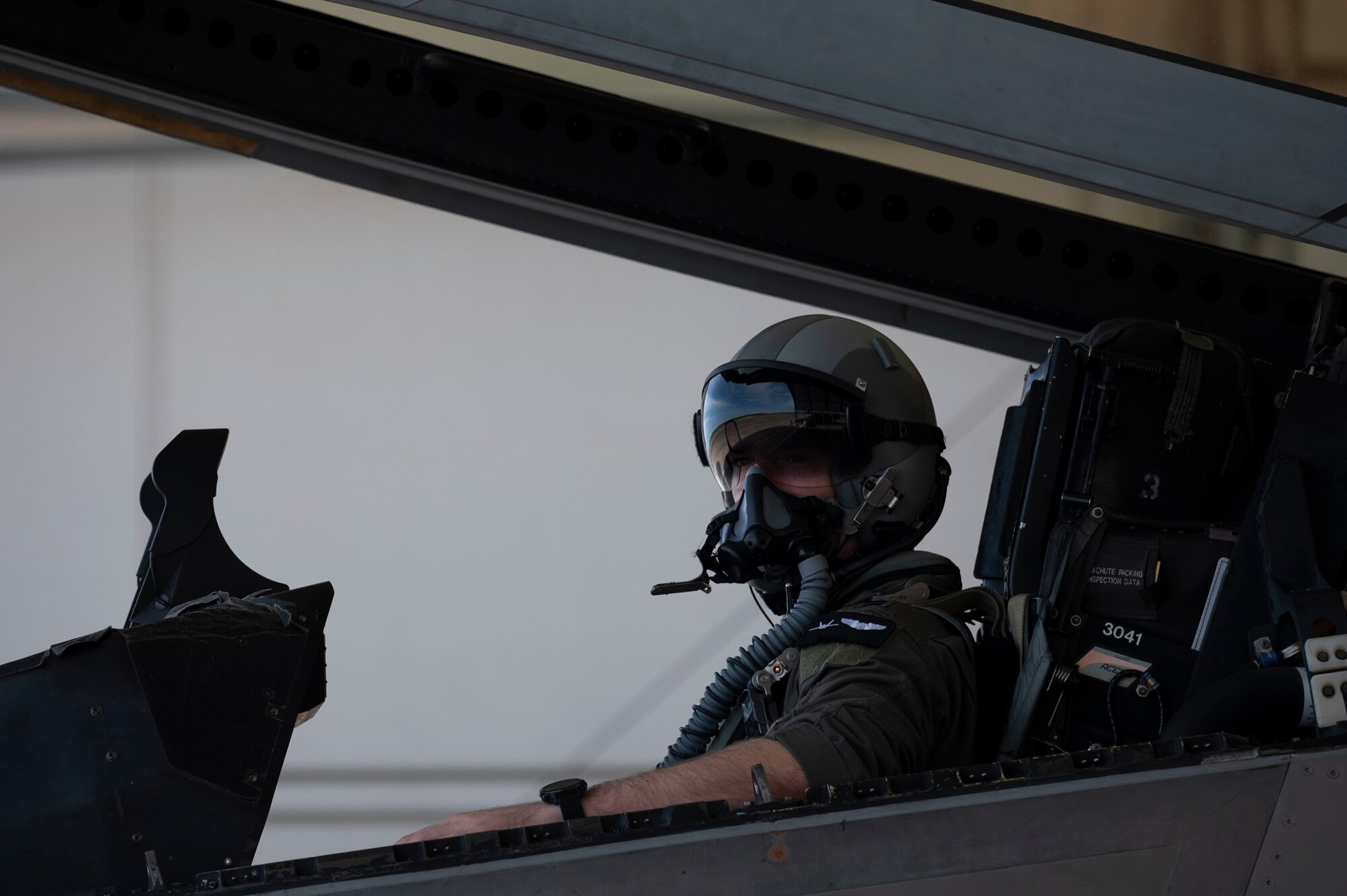 A pilot sits in the cockpit of an F-22 Raptor