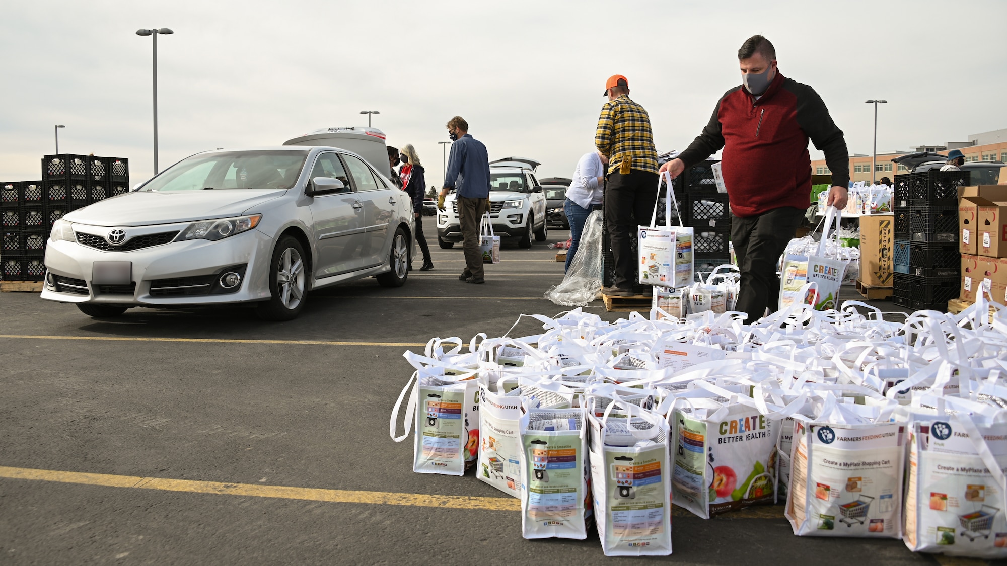 Volunteers load food donations into vehicles.