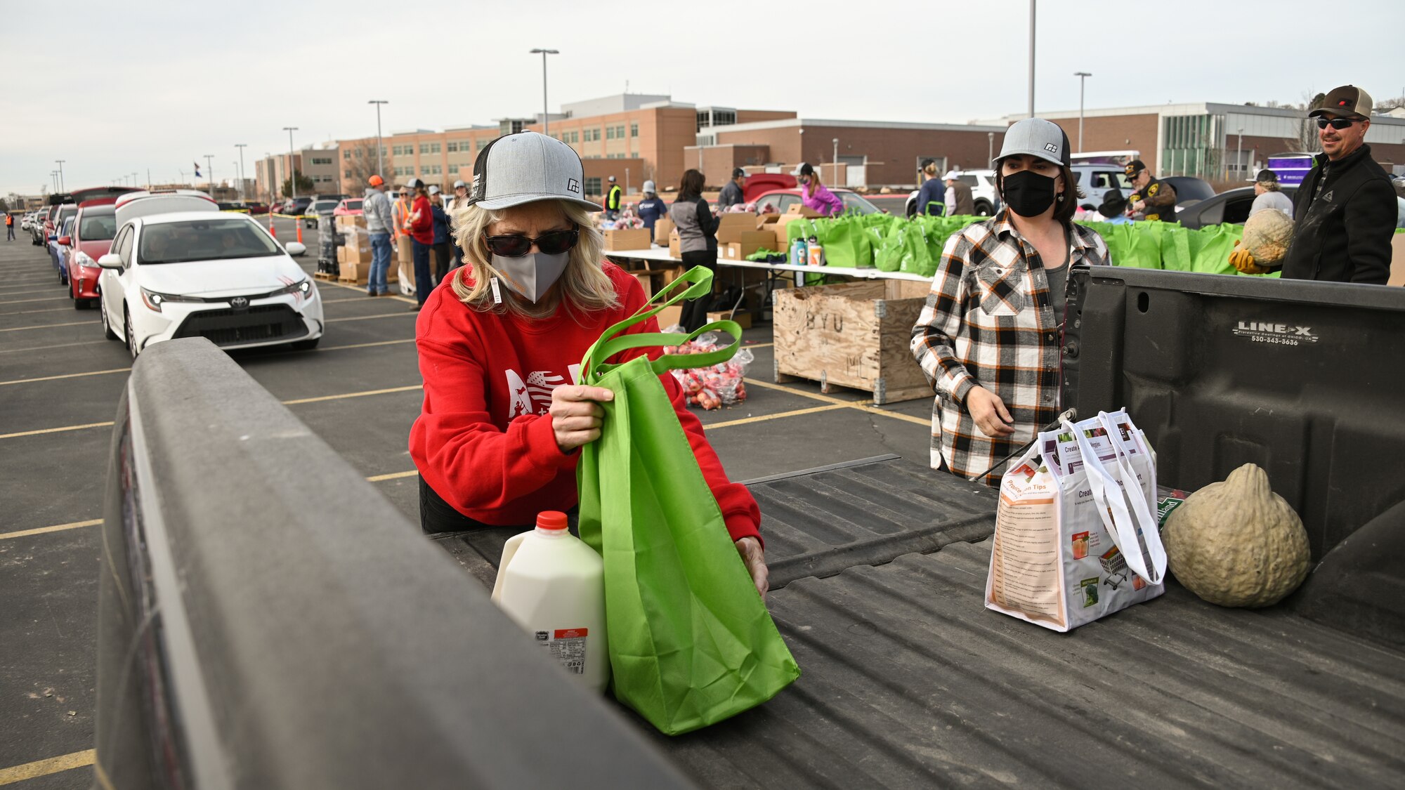 Volunteers load food donations into vehicles.