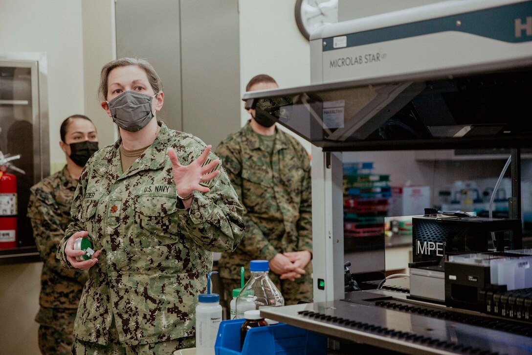 U.S. Navy Lt. Cmdr. Meredith Dozier explains the capabilities of the toxicology lab at Air Force Mortuary Affairs Operations, Dover Air Force Base, Dover, Delaware, Feb. 8, 2022. The Sergeant Major of the Marine Corps conducted the visit to thank the service members responsible for receiving and caring for fallen service members. The Armed Forces Medical Examiner System provides the Department of Defense and other federal agencies comprehensive forensic investigative services, to include forensic pathology, DNA Forensics, forensic toxicology, and medical mortality surveillance. (U.S. Marine Corps photo by Staff Sgt. Victoria Ross)