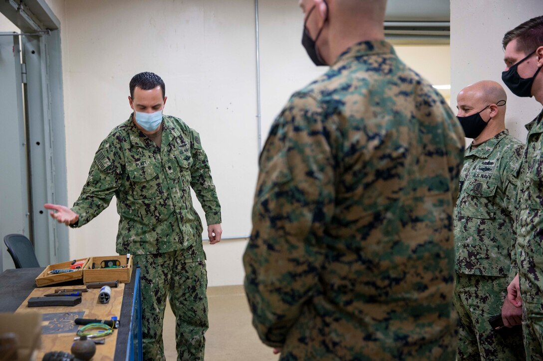 U.S. Marine Corps Sgt. Maj. Troy E. Black, the 19th Sergeant Major of the Marine Corps, and the Master Chief Petty Officer of the Navy Russell Smith, view a display of explosive ordnance identified by safety devices before entering Armed Forces Medical Examiner System at Dover Air Force Base, Dover, Delaware, Feb. 8, 2022. The Sergeant Major of the Marine Corps conducted the visit to thank the service members responsible for receiving and caring for fallen service members. The Armed Forces Medical Examiner System provides the Department of Defense and other federal agencies comprehensive forensic investigative services, to include forensic pathology, DNA Forensics, forensic toxicology, and medical mortality surveillance. (U.S. Marine Corps photo by Staff Sgt. Victoria Ross)