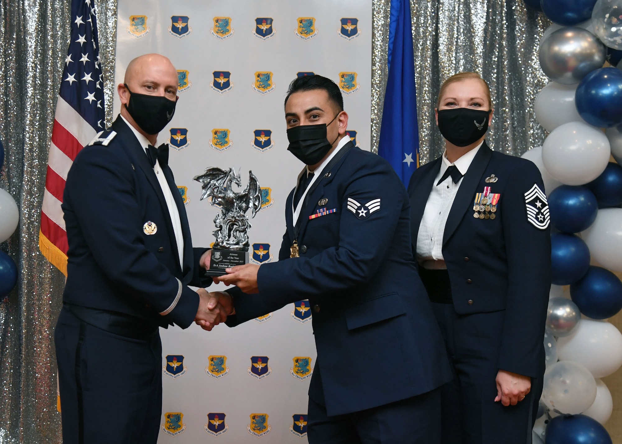 U.S. Air Force Col. William Hunter, 81st Training Wing commander, and Chief Master Sgt. Sarah Esparza, 81st TRW command chief, present Senior Airman Joshua Rodriguez, 81st Training Support Squadron cyber systems technician, with the Airman of the Year award during the 81st Training Wing's 2021 Annual Awards Ceremony inside the Bay Breeze Event Center at Keesler Air Force Base, Mississippi, Feb. 17, 2022. During the ceremony, base leadership recognized outstanding Airmen and civilians from across the installation for their accomplishments throughout 2021. (U.S. Air Force photo by Kemberly Groue)