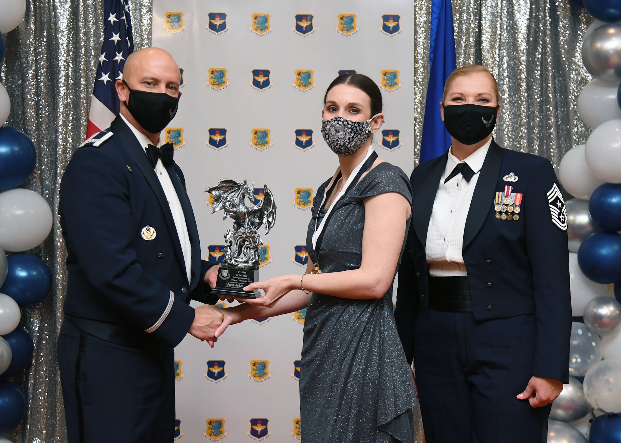 U.S. Air Force Col. William Hunter, 81st Training Wing commander, and Chief Master Sgt. Sarah Esparza, 81st TRW command chief, present Macey Behee, 81st Contracting Squadron purchasing agent, with the Civilian of the Year award, Non-Supervisor Category I , during the 81st Training Wing's 2021 Annual Awards Ceremony inside the Bay Breeze Event Center at Keesler Air Force Base, Mississippi, Feb. 17, 2022. During the ceremony, base leadership recognized outstanding Airmen and civilians from across the installation for their accomplishments throughout 2021. (U.S. Air Force photo by Kemberly Groue)