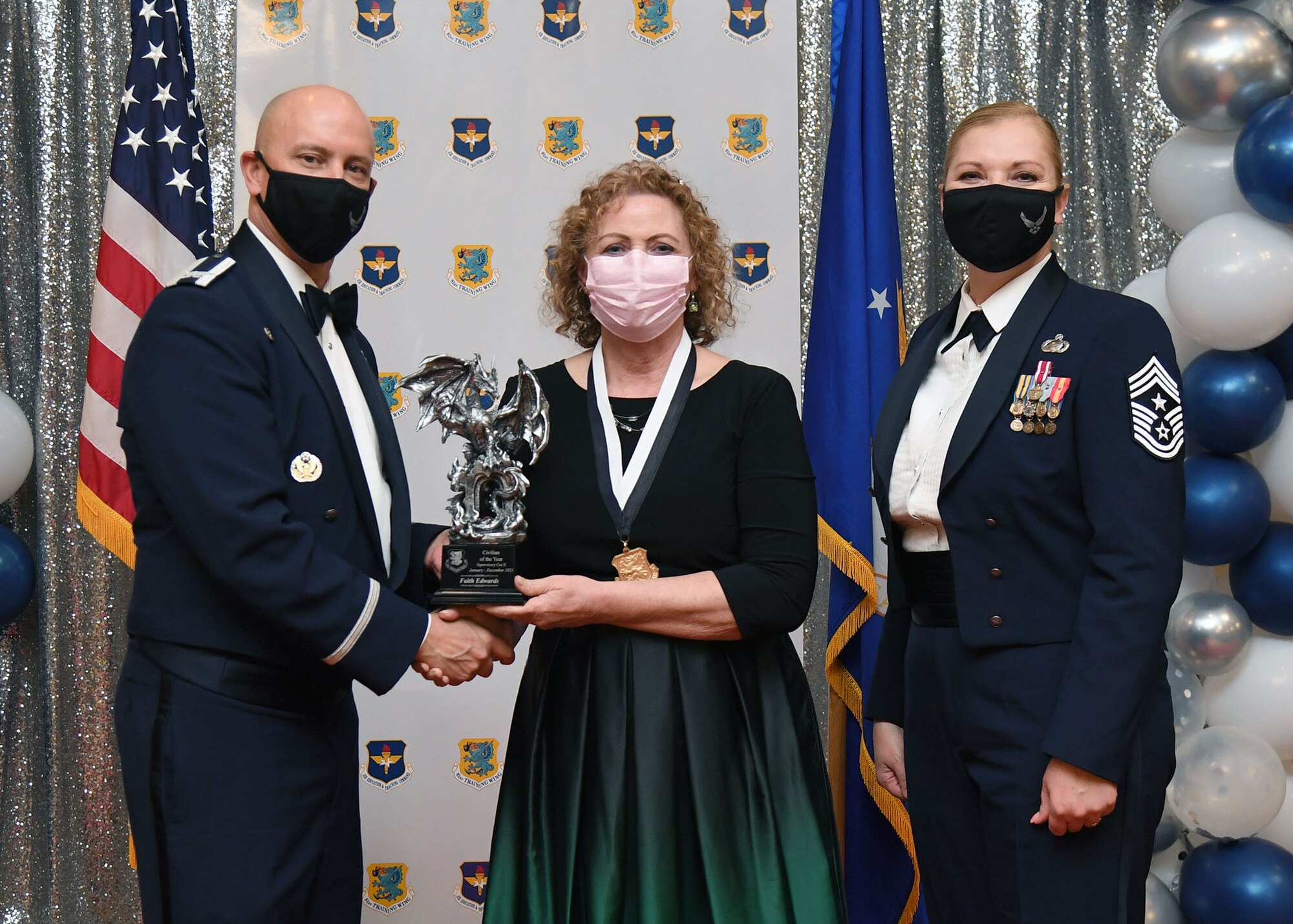 U.S. Air Force Col. William Hunter, 81st Training Wing commander, and Chief Master Sgt. Sarah Esparza, 81st TRW command chief, present Faith Edwards, 81st Diagnostic and Therapeutics Squadron breast imaging supervisor, with the Civilian of the Year award, Supervisor Category II, during the 81st Training Wing's 2021 Annual Awards Ceremony inside the Bay Breeze Event Center at Keesler Air Force Base, Mississippi, Feb. 17, 2022. During the ceremony, base leadership recognized outstanding Airmen and civilians from across the installation for their accomplishments throughout 2021. (U.S. Air Force photo by Kemberly Groue)