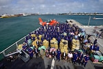 Group photo of Coast Guard personnel posing with $1.06 billion in illegal narcotics.