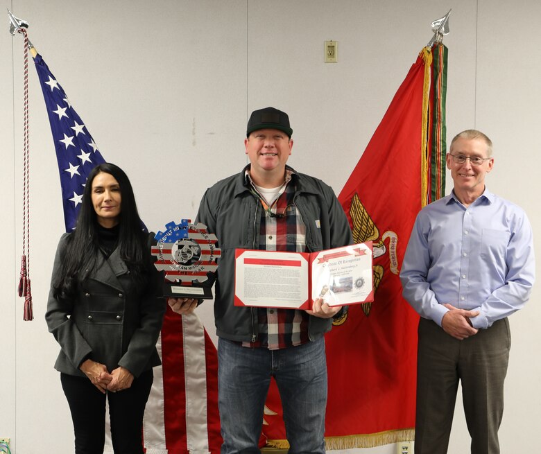 Richard Halstenburg, center, industrial engineering technician, Production Plant Barstow (PPB), received PPB's Civilian-Marine of the Year award for 2021. Malissa Santos, left, trades division manager, PPB, and Robert C. Schwartz, plant manager, PPB, presented the award to Halstenburg in a brief ceremony held at Marine Corps Logistics Base Barstow, Calif.