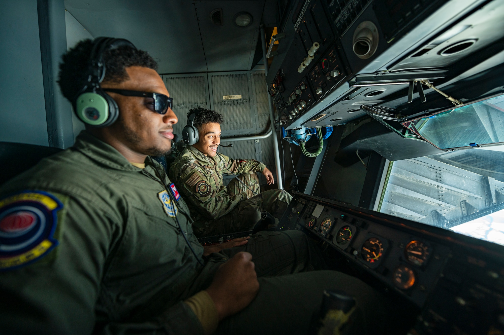 Airmen sit in the boom operator station