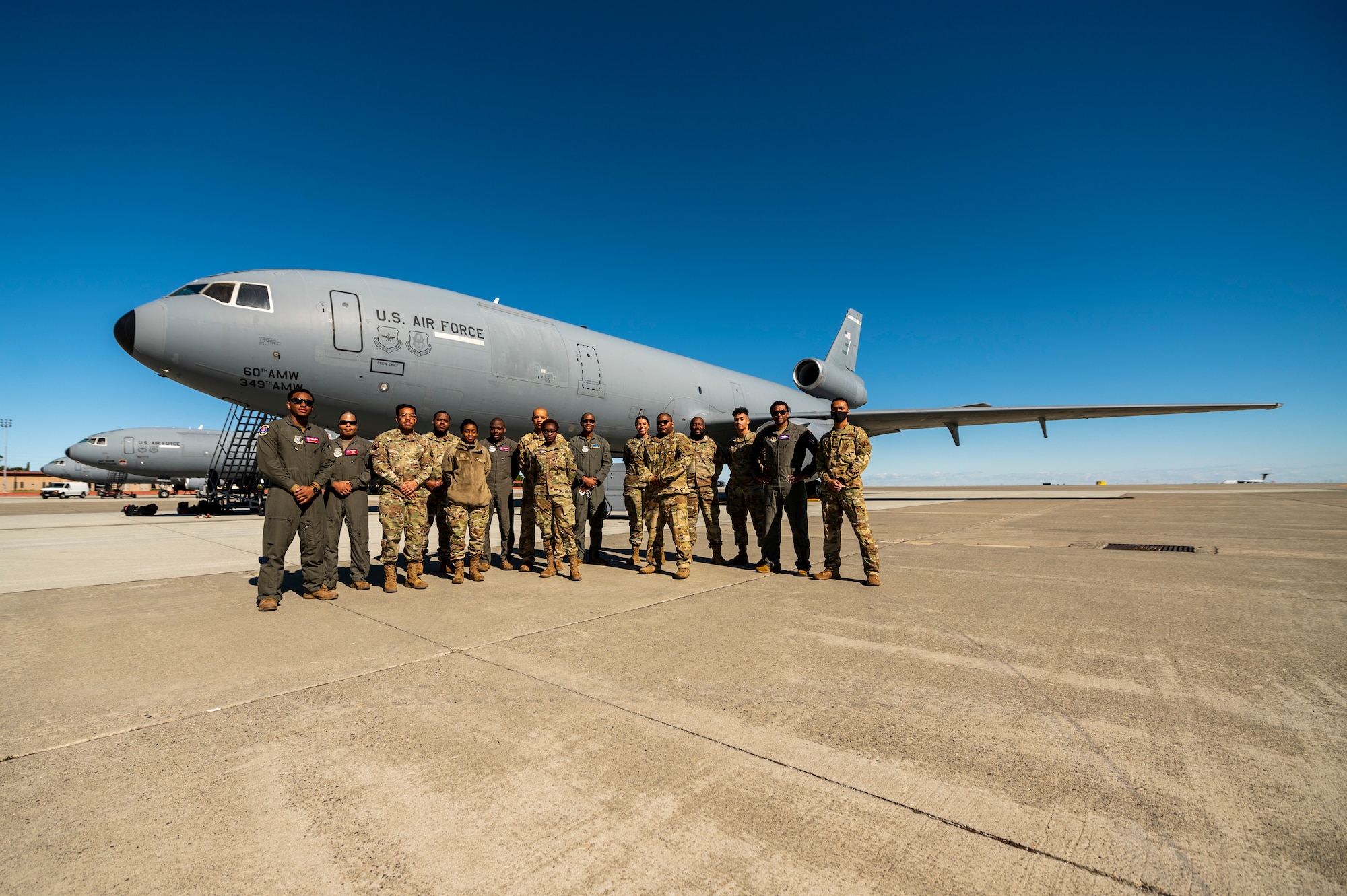 Airmen gather around a plane for a photo