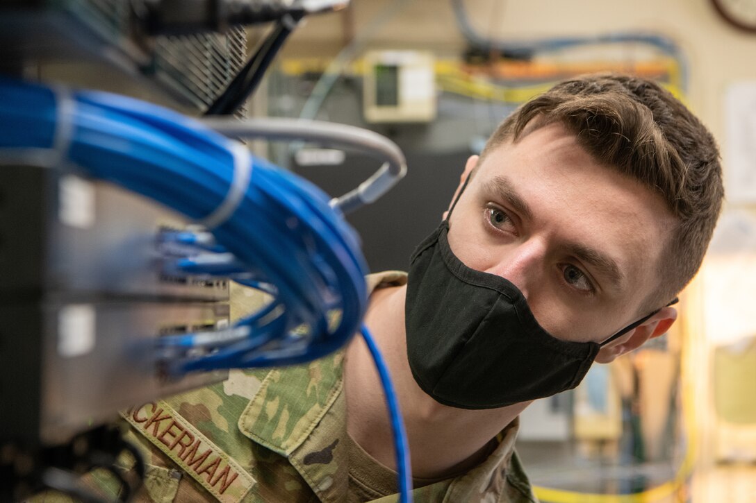 An airman checks cable connections.