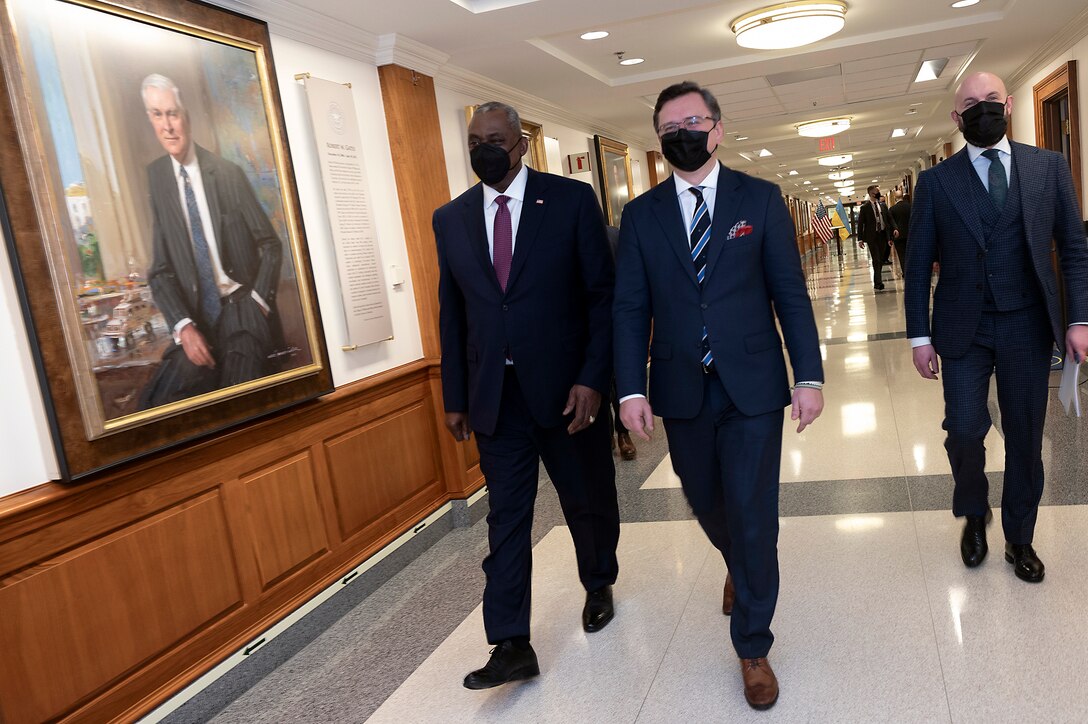 Two mean walk along a hallway with a photographic display.