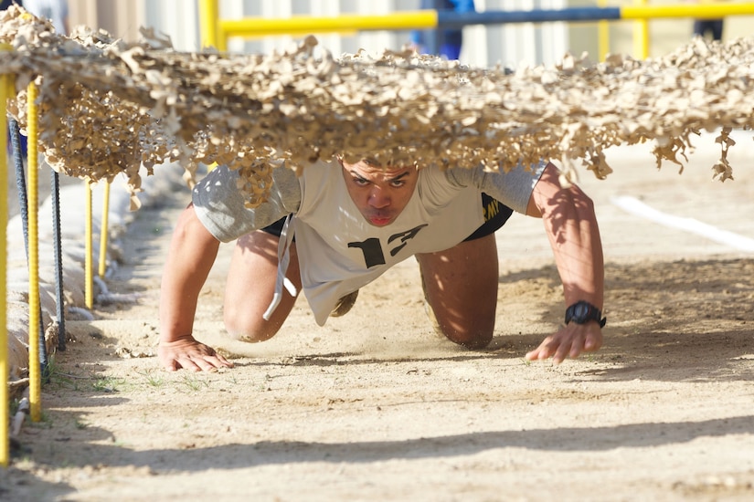 An athlete crawls under netting.