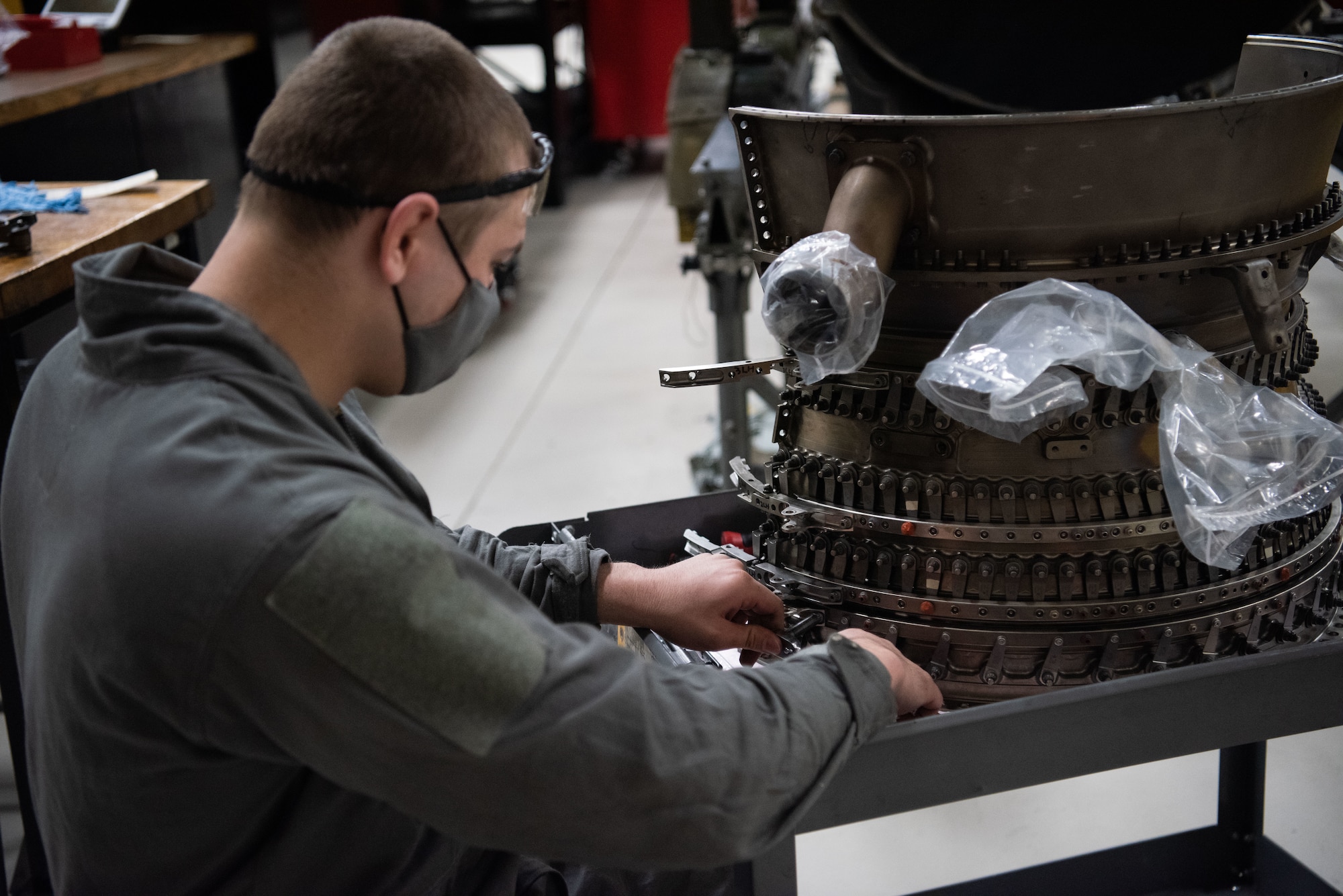 An Airman works on an engine piece.