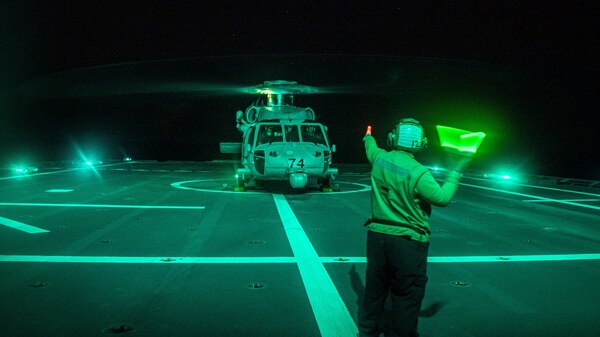 SOUTH CHINA SEA (Jan. 24, 2022) Aviation Structural Mechanic 1st Class Cari McPheeters, from Milwaukie, Oregon, signals an MH-60S Sea Hawk helicopter, assigned to the “Blackjacks” of Helicopter Sea Combat Squadron (HSC) 21, during flight operations aboard Independence-variant littoral combat ship USS Charleston (LCS 18). Charleston, part of Destroyer Squadron (DESRON) 7, is on a rotational deployment in the U.S. 7th Fleet area of operation to enhance interoperability with partners and serve as a ready-response force in support of a free and open Indo-Pacific region. (U.S. Navy photo by Mass Communication Specialist 2nd Class Ryan M. Breeden)