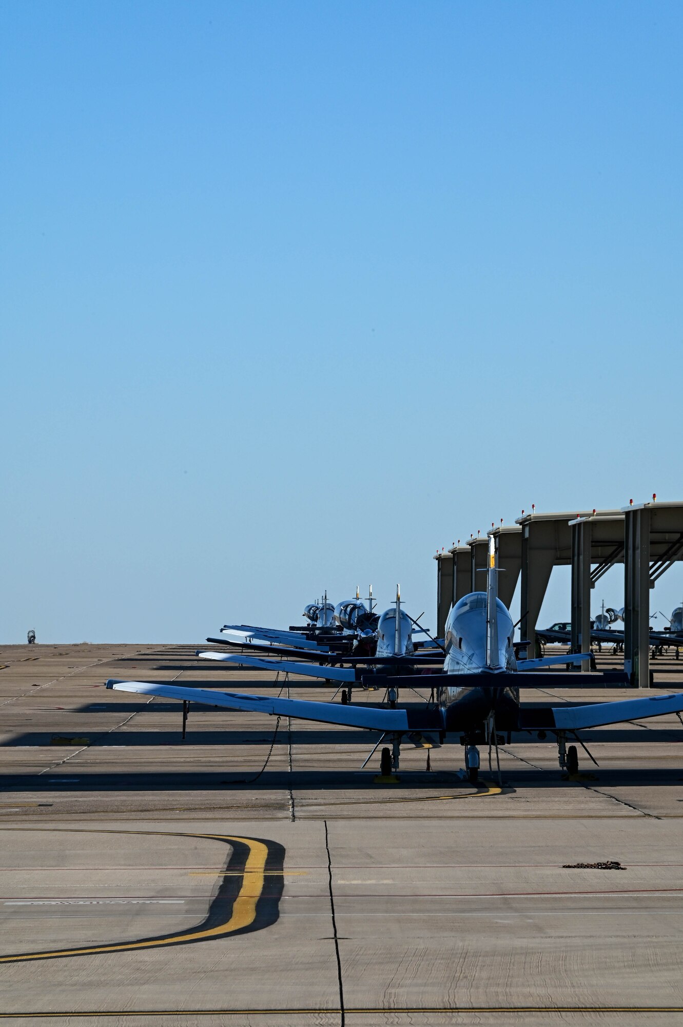T-6 Texans sit parked on the runway at Laughlin Air Force Base, Texas, Feb. 1, 2022. The T-6 is used by the United States Air Force for basic pilot training. (U.S. Air Force photo by Senior Airman Kayla Christenson)