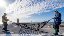 SOUTH CHINA SEA (Feb. 2, 2022) Sailors prepare for a vertical replenishment with fleet replenishment oiler USNS Guadalupe (T-AO 200) aboard Independence-variant littoral combat ship USS Charleston (LCS 18). Charleston, part of Destroyer Squadron (DESRON) 7, is on a rotational deployment in the U.S. 7th Fleet area of operation to enhance interoperability with partners and serve as a ready-response force in support of a free and open Indo-Pacific region. (U.S. Navy photo by Mass Communication Specialist 2nd Class Ryan M. Breeden)