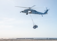 SOUTH CHINA SEA (Jan. 26, 2022) An MH-60S Sea Hawk helicopter, assigned to the “Blackjacks” of Helicopter Sea Combat Squadron (HSC) 21, conducts a flight maneuver above the flight deck aboard Independence-variant littoral combat ship USS Charleston (LCS 18), during a vertical replenishment-at-sea. Charleston, part of Destroyer Squadron (DESRON) 7, is on a rotational deployment in the U.S. 7th Fleet area of operation to enhance interoperability with partners and serve as a ready-response force in support of a free and open Indo-Pacific region. (U.S. Navy photo by Mass Communication Specialist 2nd Class Ryan M. Breeden)