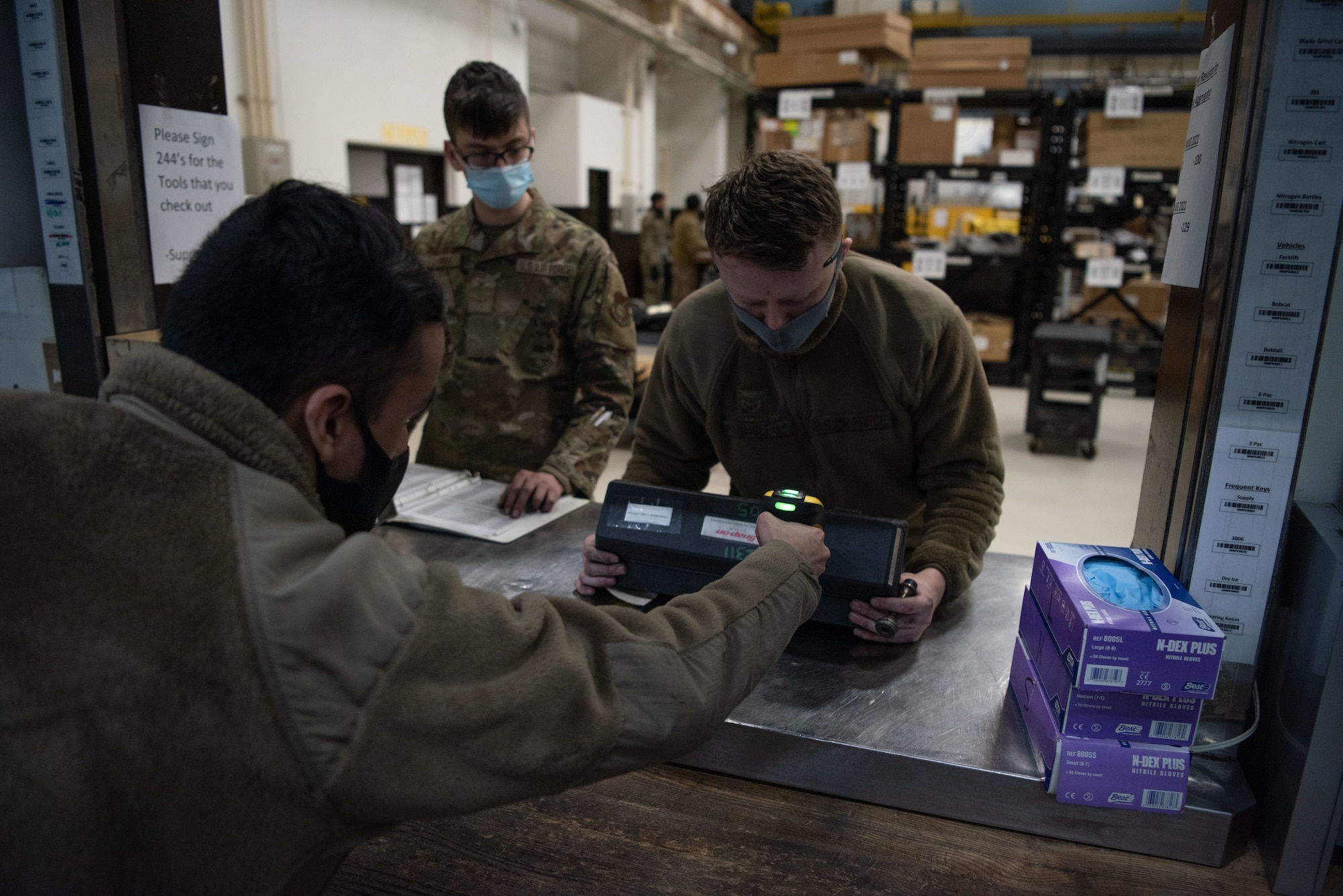 An Airman scans a tool box for another Airman to use to repair an engine.