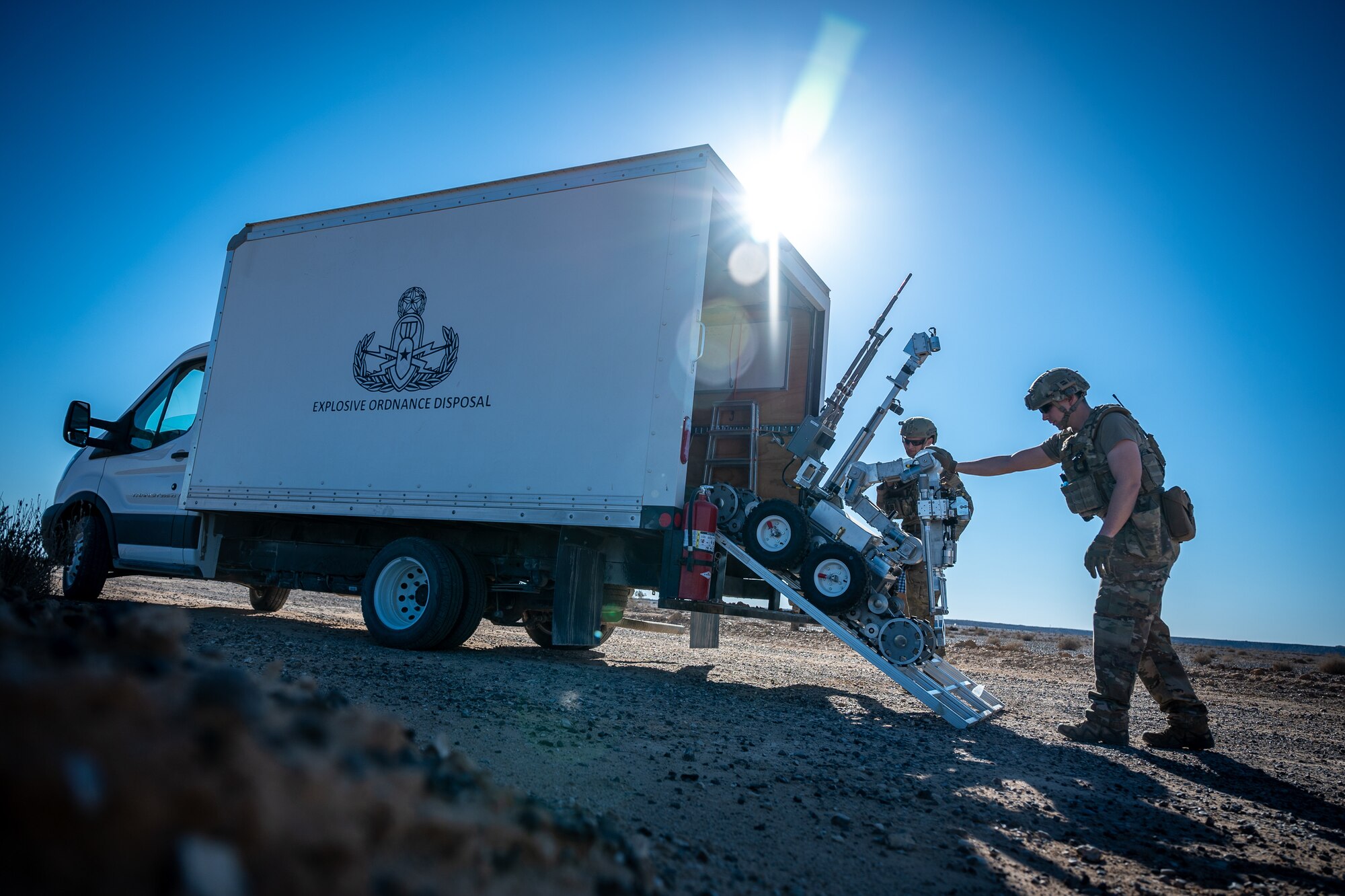 Team members from the 332d Expeditionary Explosive Ordnance Disposal unit off load an EOD robot that will be used to safely remove a downed small unmanned aircraft system to a safe distance for further investigation during a counter SUAS training exercise in Southwest Asia Feb. 12, 2022. (U.S. Air Force photo by Master Sgt. Christopher Parr)