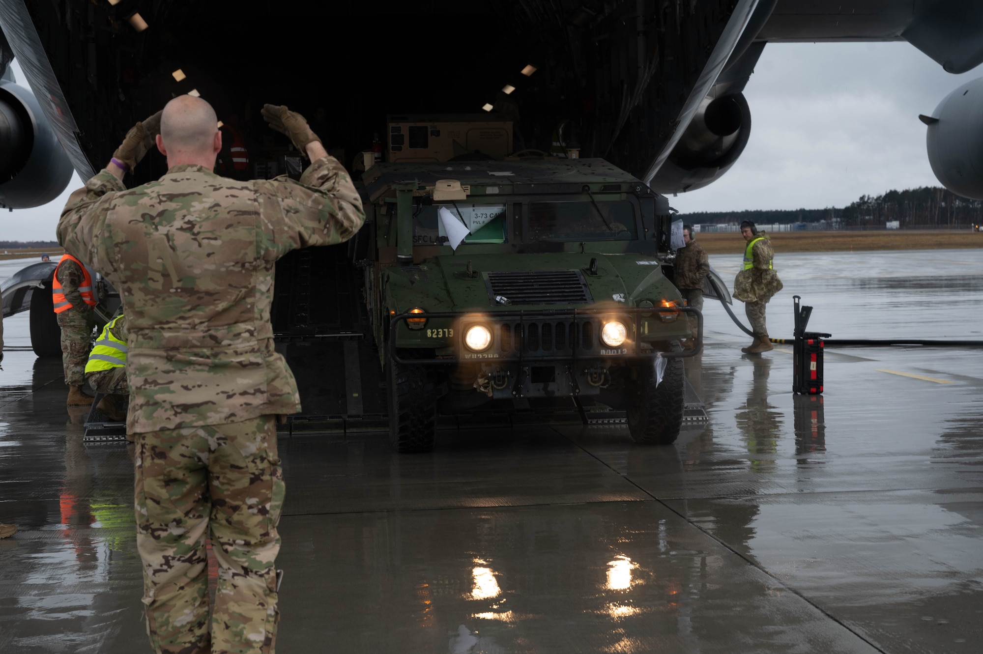 An Airman marshals a U.S. Army Humvee.