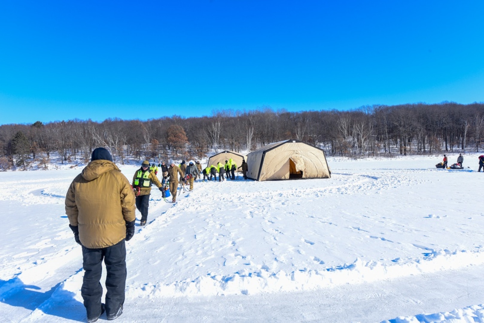 Students from the joint-service Cold Water Ice Diving course finish staging the dive site to move to the next phase of instruction on Lake Ferrell, Minn., Feb. 2, 2022. Divers from the U.S. Coast Guard, U.S. Army and U.S. Navy participated in a Cold Water Ice Diving Course located on Minnesota National Guard Base Camp Ripley to gain the skills needed to dive in cold-water and ice environments. (U.S. Coast Guard Photo by Petty Officer 3rd Class Gregory Schell)