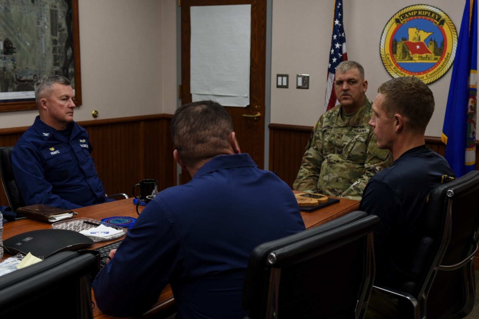 U.S. Coast Guard Capt. Paul Frantz, Lt. Nicholas Pavlik, and Chief Warrant Officer Sean Eversole meet with U.S. Army Brig. Gen. Lowell Kruse, senior commander of Camp Ripley Training Center, Feb. 2, 2022, at Camp Ripley, Minnesota. The Coast Guard and the National Guard worked together to coordinate the logistics of the Cold Water Ice Diving course. (U.S. Coast Guard photo by Petty Officer 3rd Class Jessica Fontenette)