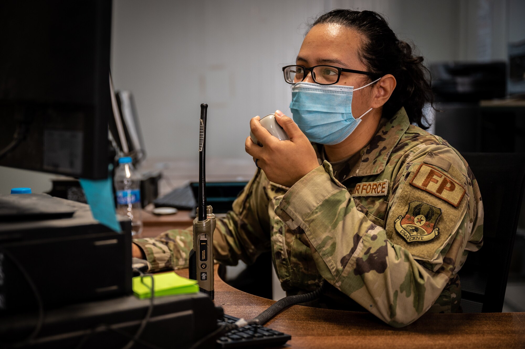 Senior Airman Ashley Fair, 332d Expeditionary Civil Engineer Squadron force protection team member, makes a radio call for an escort driver to report to the escort control center inside the Force Protection office in Southwest Asia, Feb. 18, 2022. (U.S. Air Force photo by Master Sgt. Christopher Parr)