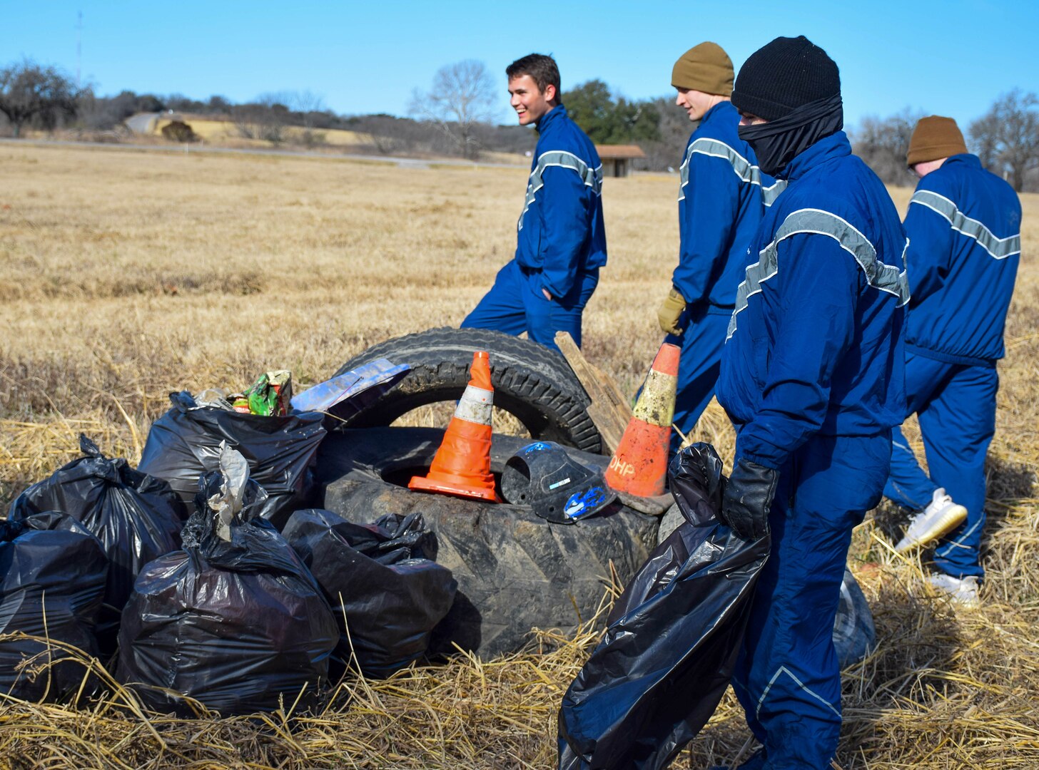 733rd Training Squadron students gather for a group photograph near the garbage they collected at Stillman Park, Joint Base San Antonio-Lackland, Texas, Feb. 18, 2022. Four students in the 733rd TRS volunteered in a joint cleanup event coordinated by the 502nd Installation Support Group to remove garbage and debris from on-base parks and waterways. (U.S. Air Force photo by Airman Mark Colmenares)