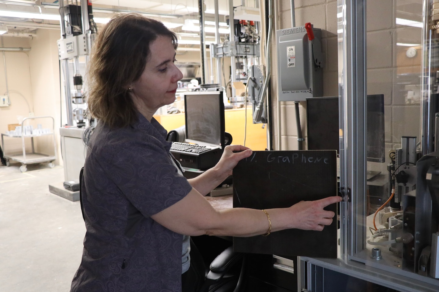 U.S. Army Engineer Research and Development Center (ERDC) researcher, Dr. Mine Ucak-Astarlioglu, displays a graphene-containing composite panel. These composite panel systems made from advanced graphene-based materials present innovative approaches in multi-functionality, lighter weight and cost effective solutions in force protection. (U.S. Army Corps of Engineers photo)