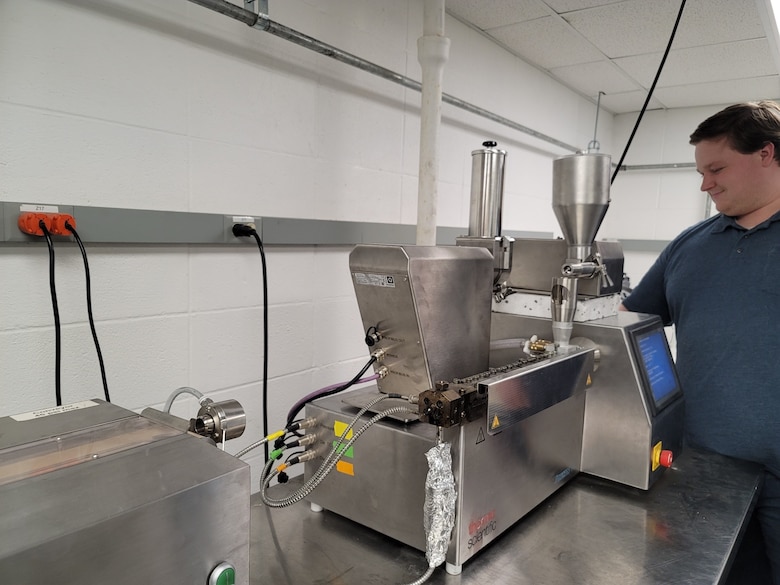 U.S. Army Engineer Research and Development Center (ERDC) researcher, Hayden Hanna, uses a pilot-scale extruder to optimize extrusion parameters and improve nanophase dispersion of graphene/ polymer nanocomposite materials. (U.S. Army Corps of Engineers photo)