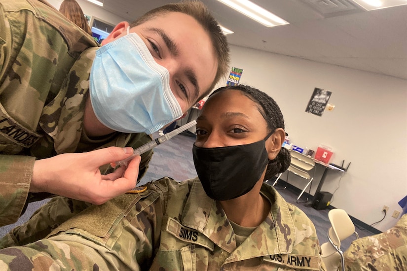 Spc. Nadiah Sims, right, an ammunition specialist with the Fort Indiantown Gap Training Center from East Stroudsburg, Pa., poses with Spc. Justin Landes, left, of the Pennsylvania National Guard Joint Force Headquarters Medical Detachment during a vaccination clinic in Enola, Pa., in 2021. (Courtesy photo)