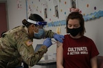 Spc. Han Thach, left, a combat medic with the Pennsylvania National Guard, administers the COVID-19 vaccine to a patient in Enola, Pa., March 26, 2021. Thach was part of the Guard mission to vaccinate Pennsylvania teachers, child-care workers and other staff.