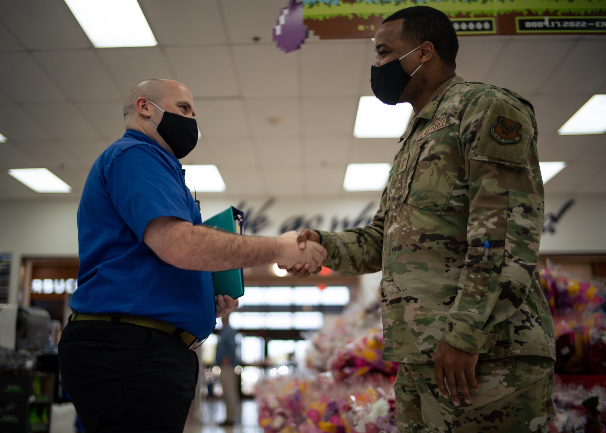 U.S. Air Force Chief Master Sgt. Kevin Osby, Army and Air Force Exchange Service’s senior enlisted advisor, coins an Exchange associate for his dedicated service at MacDill Air Force Base, Florida, Feb. 22, 2022.