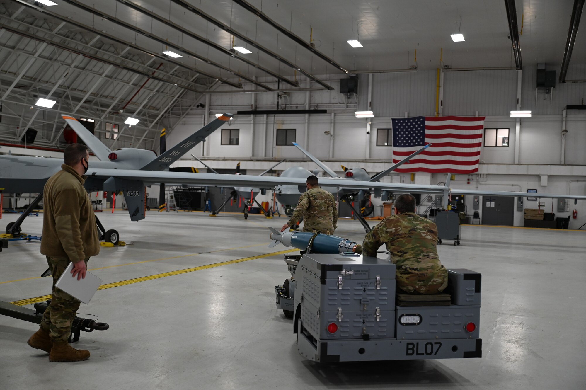 Airmen from the 174th Maintenance Group line up an inert bomb for installation for a training mission on Hancock Field Air Force Base, New York on February 8, 2022. This is a requirement aimed to keep weapon load crews proficient in their jobs. (U.S. Air National Guard photo by Master Sgt. Barbara Olney)