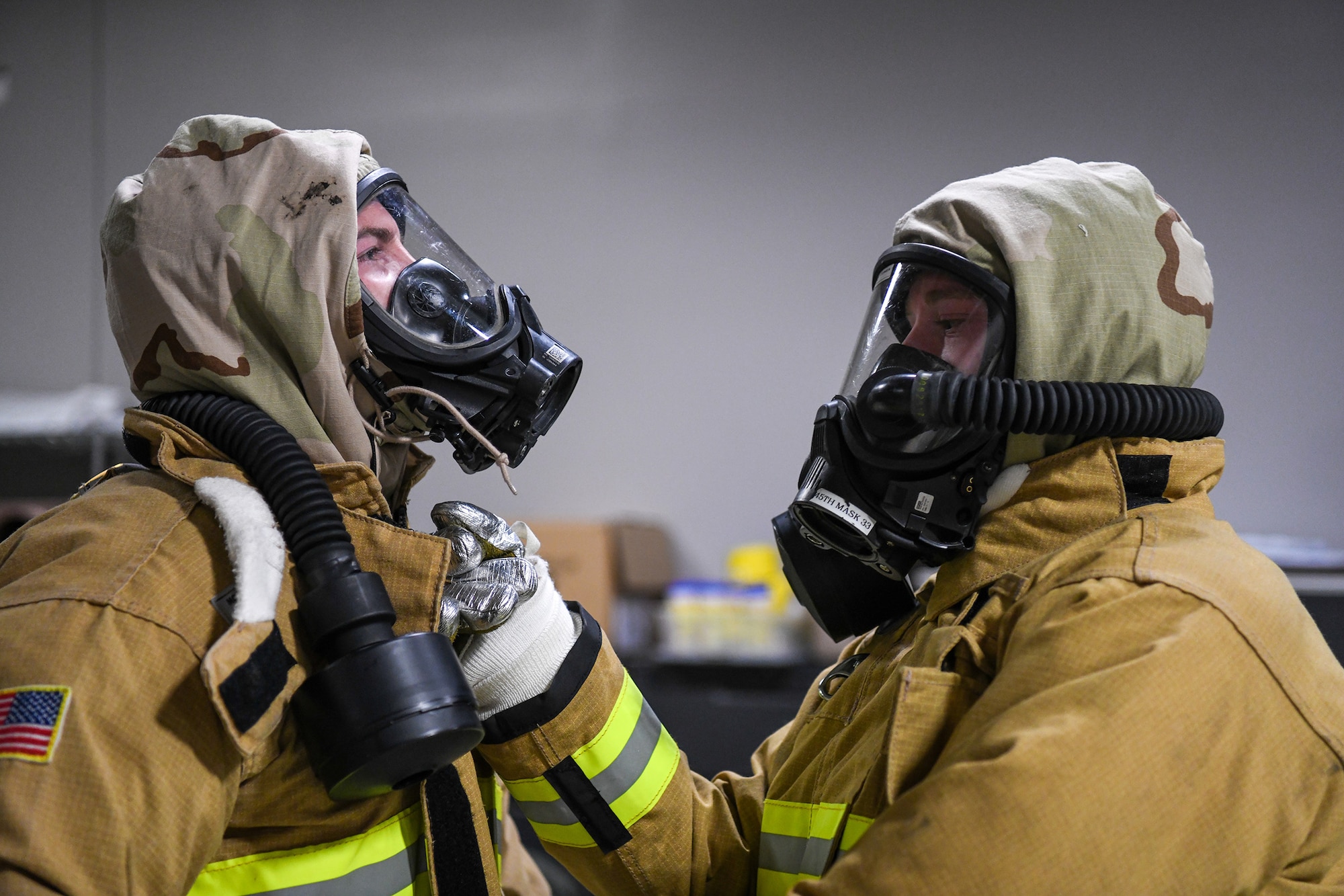 Airman 1st Class Jacob Jones secures Staff Sgt. Nathan Jennings’ suit during joint firefighter integrated response ensemble training, Feb. 13, 2022.
