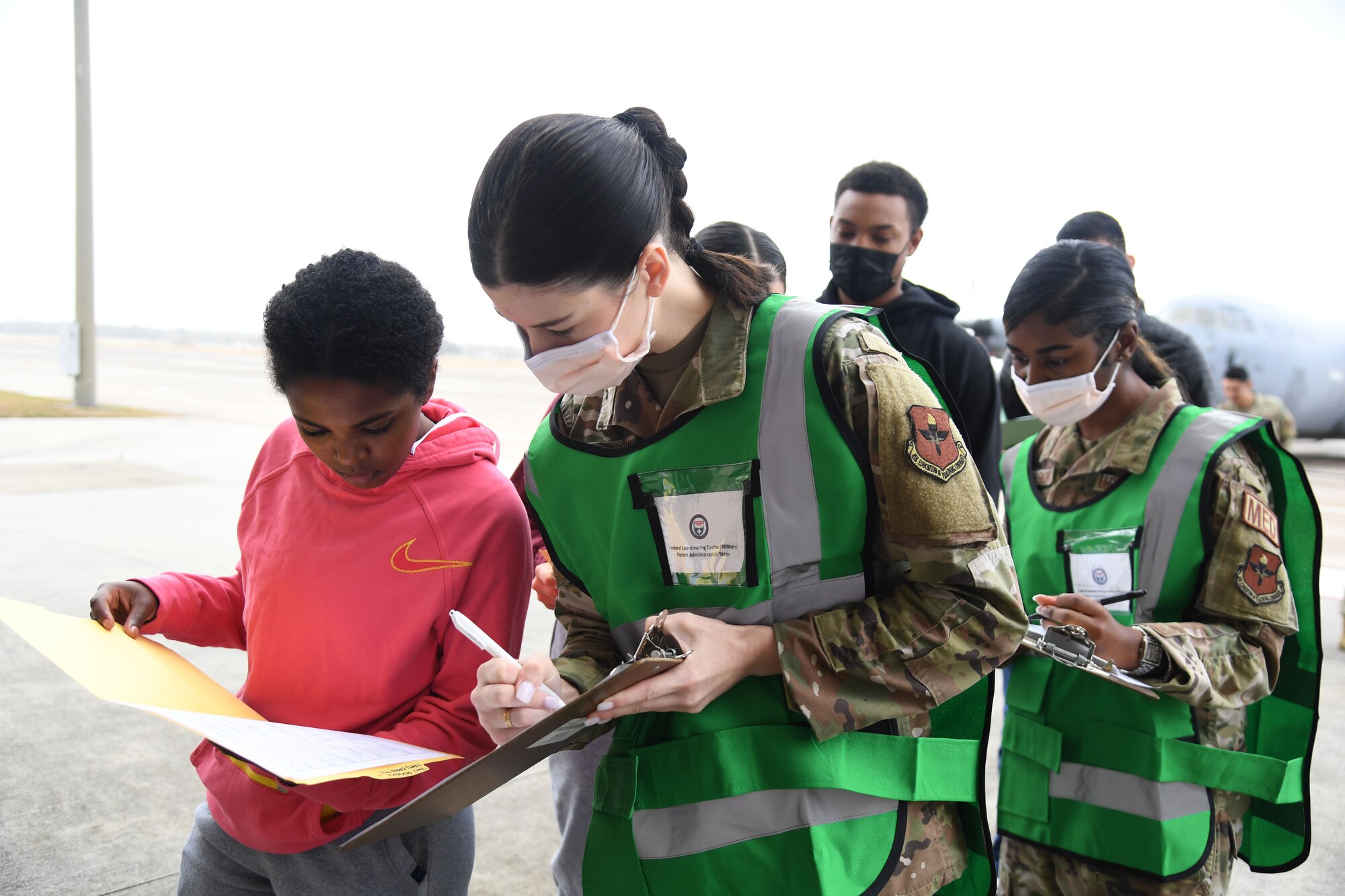 U.S. Air Force Senior Airman Katie Blackenby, 81st Medical Support Squadron administration technician, receives patient information from Airman Basic Setota Touchette, 335th Training Squadron student, as she portrays a patient during the National Disaster Medical System Exercise outside the 41st Aerial Port Squadron building at Keesler Air Force Base, Mississippi, Feb. 17, 2022. Keesler's Federal Coordination Center was activated and received more than 20 patients during the exercise scenario, which included the New Madrid Fault erupting, sparking an earthquake to occur in Tennessee causing extensive damage and injuring many people. Members of the 81st Medical Group participated in the event in order to better prepare themselves for real-world situations. (U.S. Air Force photo by Kemberly Groue)