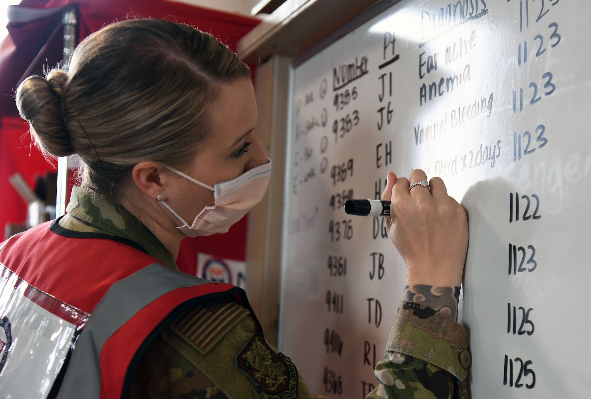 U.S. Air Force Staff Sgt. Jessica McCleary, 81st Operational Medical Readiness Squadron warrior clinic NCO in charge, logs info on a patient tracking board during the National Disaster Medical System Exercise inside the 41st Aerial Port Squadron building at Keesler Air Force Base, Mississippi, Feb. 17, 2022. Keesler's Federal Coordination Center was activated and received more than 20 patients during the exercise scenario, which included the New Madrid Fault erupting, sparking an earthquake to occur in Tennessee causing extensive damage and injuring many people. Members of the 81st Medical Group participated in the event in order to better prepare themselves for real-world situations. (U.S. Air Force photo by Kemberly Groue)