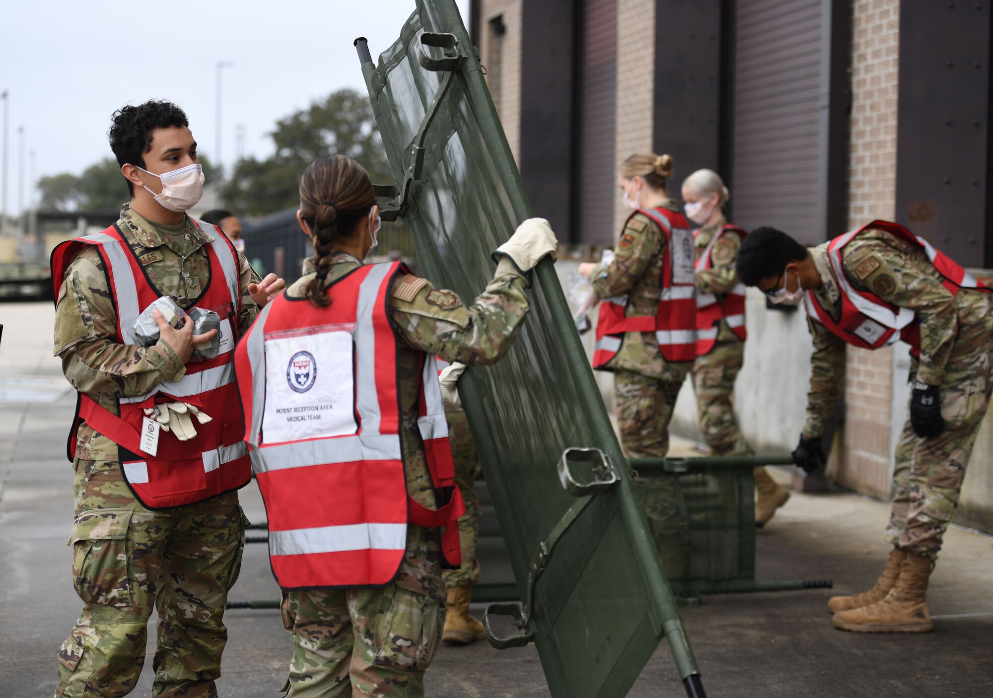 U.S Air Force Airmen 1st Class Jesse Gonzales and Elizabeth Contreras, 81st Healthcare Operations Squadron medical technicians, prepare a stretcher for patients during the National Disaster Medical System Exercise outside the 41st Aerial Port Squadron building at Keesler Air Force Base, Mississippi, Feb. 17, 2022. Keesler's Federal Coordination Center was activated and received more than 20 patients during the exercise scenario, which included the New Madrid Fault erupting, sparking an earthquake to occur in Tennessee causing extensive damage and injuring many people. Members of the 81st Medical Group participated in the event in order to better prepare themselves for real-world situations. (U.S. Air Force photo by Kemberly Groue)