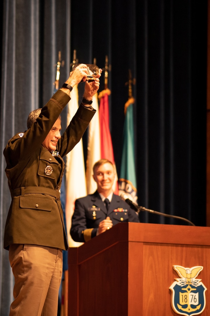 Gen. Paul Nakasone, Commander of U.S. Cyber Command and Director of the National Security Agency, holds up a bottled ship gifted to him by 1/c Sean Hunter, Regimental Commander of the Corps of Cadets, Jan. 20, 2022. Nakasone visited the Coast Guard Academy to discuss the vitality of cyber security infrastructure in an increasingly technological world with both senior leadership and cadets. (U.S. Coast Guard photo by Petty Officer 3rd Class Matthew Abban)