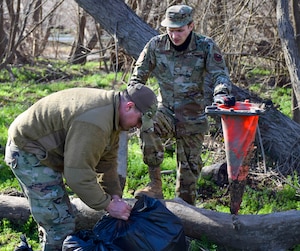 Airmen 1st Class Luis Cintron and Lee Grose, 502nd Communications Squadron client systems technicians, collect garbage at Stillman Park as part of a joint volunteer cleanup event coordinated by the 502nd Installation Support Group at Joint Base San Antonio-Lackland, Texas, Feb. 18, 2022. The cleanup removed garbage and debris from on-base parks and waterways. (U.S. Air Force photo by Airman Mark Colmenares)