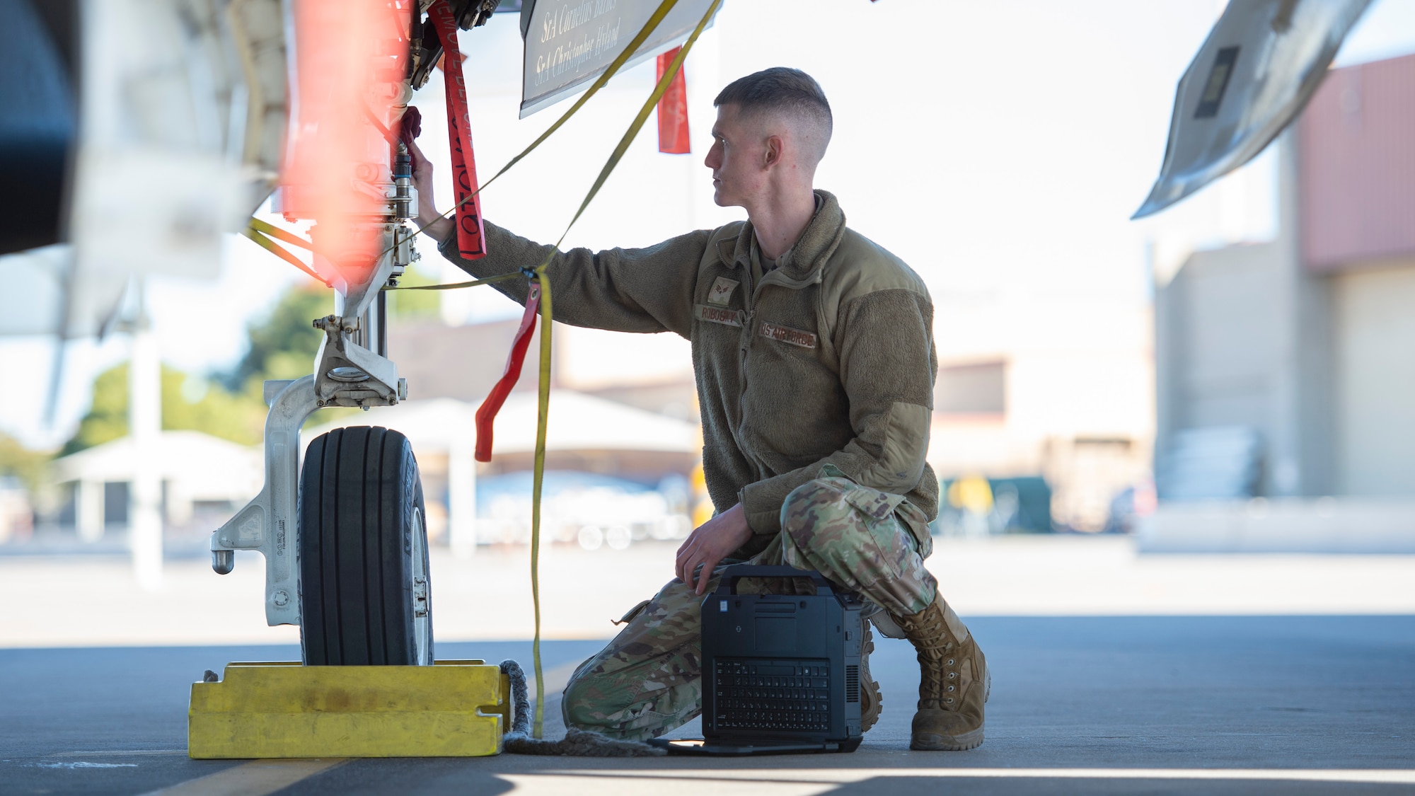 U.S. Air Force Senior Airman Aaron Robosky, 61st Aircraft Maintenance Unit F-35A Lightning II assistant dedicated crew chief, utilizes a wireless capable ruggedized laptop during an F-35 tire inspection Feb. 3, 2022, at Luke Air Force Base, Arizona. With the laptops, Airmen are able to close the time gap of task completion due to users having instant network access during daily maintenance operations. (U.S. Air Force photo by Staff Sgt. Collette Brooks)
