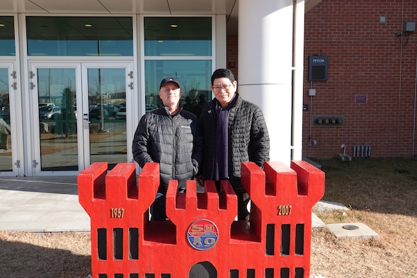 Roger St. Louis (left), former Security Operations Resident Office senior construction representative, and Lee Jung (right), electrical engineer, stand outside in front of the FED building at USAG Humphreys, South Korea, Dec. 2021. (Courtesy photo)