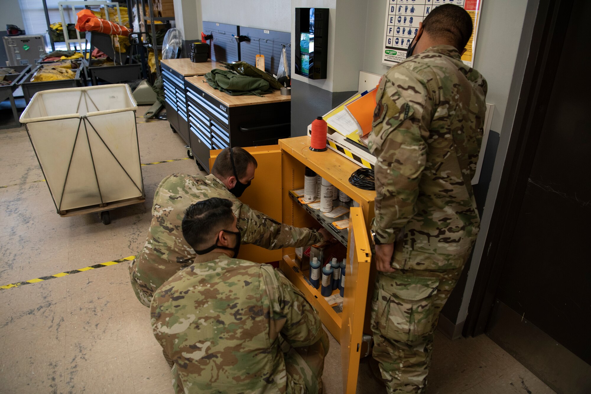U.S. Air Force Staff Sgt. Kurtis Vandevender, left, a 1st Special Operations Wing occupational safety technician, inspects a chemical storage locker with Senior Airman David Rodriguez, center, and Senior Airman Daniel Wilson, both 1st Special Operations Support Squadron aircrew flight equipment technicians, Feb. 15, 2022, at Hurlburt Field, Florida.