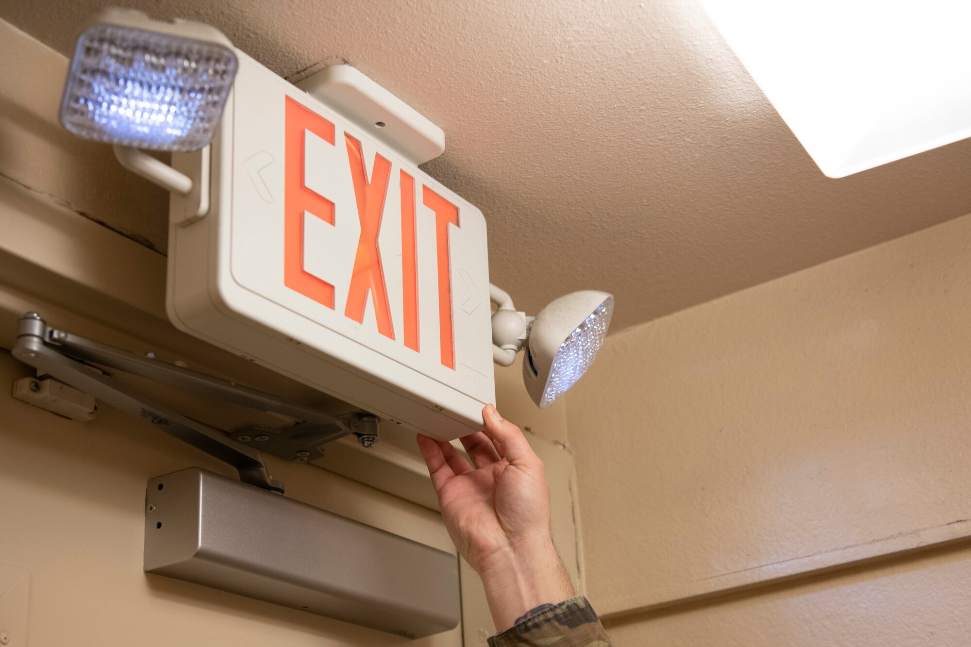 U.S. Air Force Staff Sgt. Kurtis Vandevender, a 1st Special Operations Wing occupational safety technician, tests an exit sign’s emergency lights Feb. 15, 2022, at Hurlburt Field, Florida.