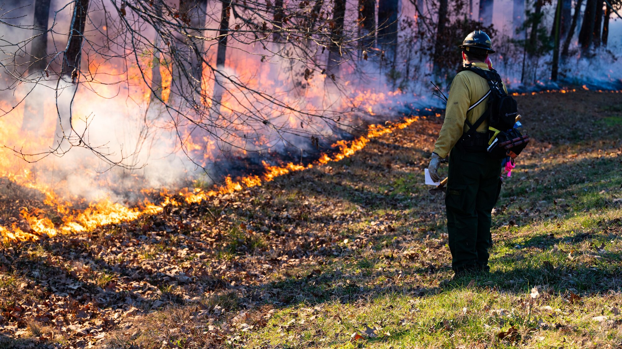 Matt Johnson, U.S. Fish and Wildlife fire management specialist, scans the perimeter of a controlled burn at Barksdale Air Force Base, Louisiana, Jan. 28, 2022.