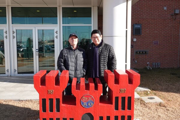 Roger St. Louis (left), former Security Operations Resident Office senior construction representative, and Lee Jung (right), electrical engineer, stand outside in front of the FED building at USAG Humphreys, South Korea, Dec. 2021. (Courtesy photo)