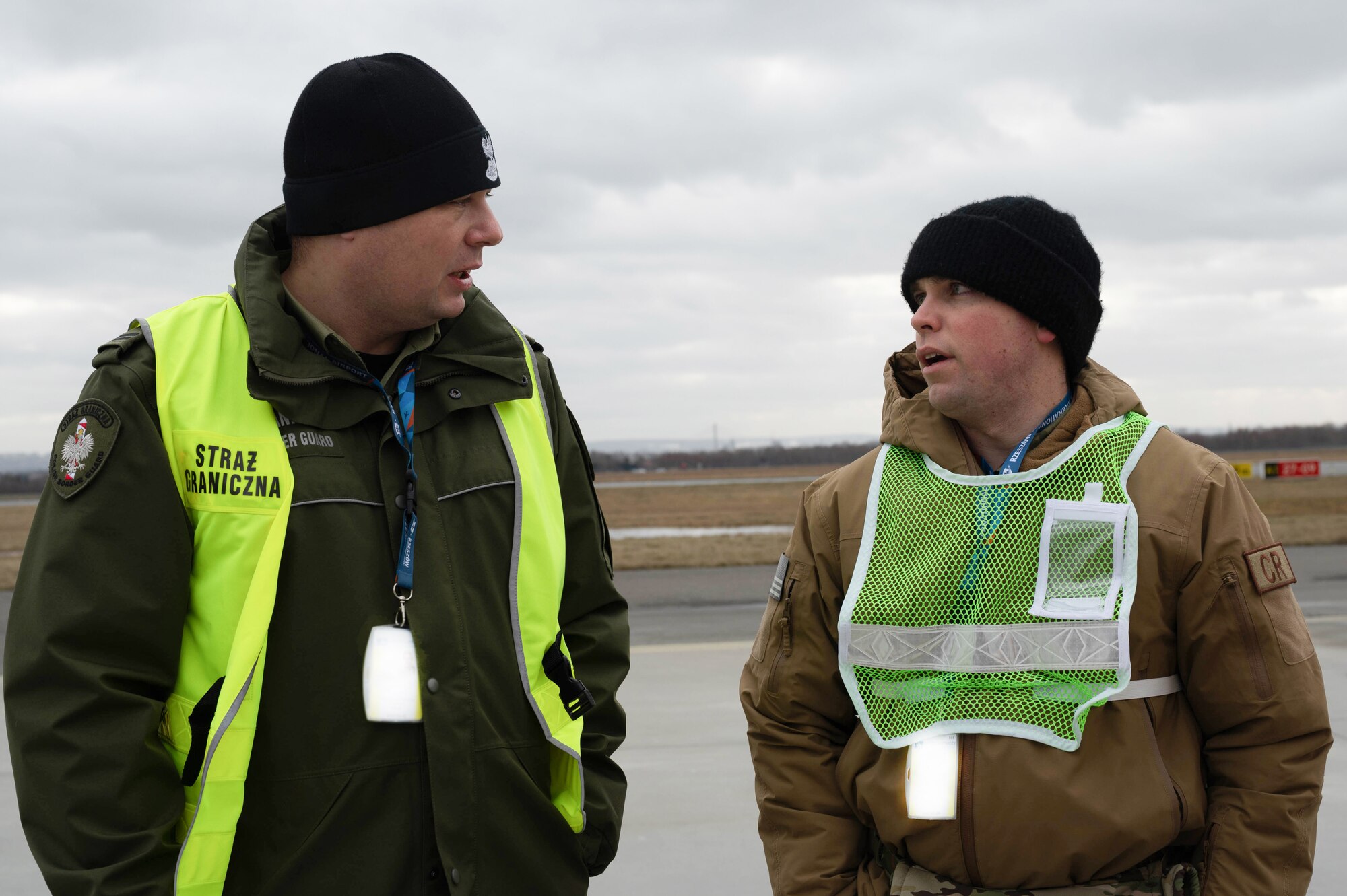 An Airman speaks with a member of Polish border control.
