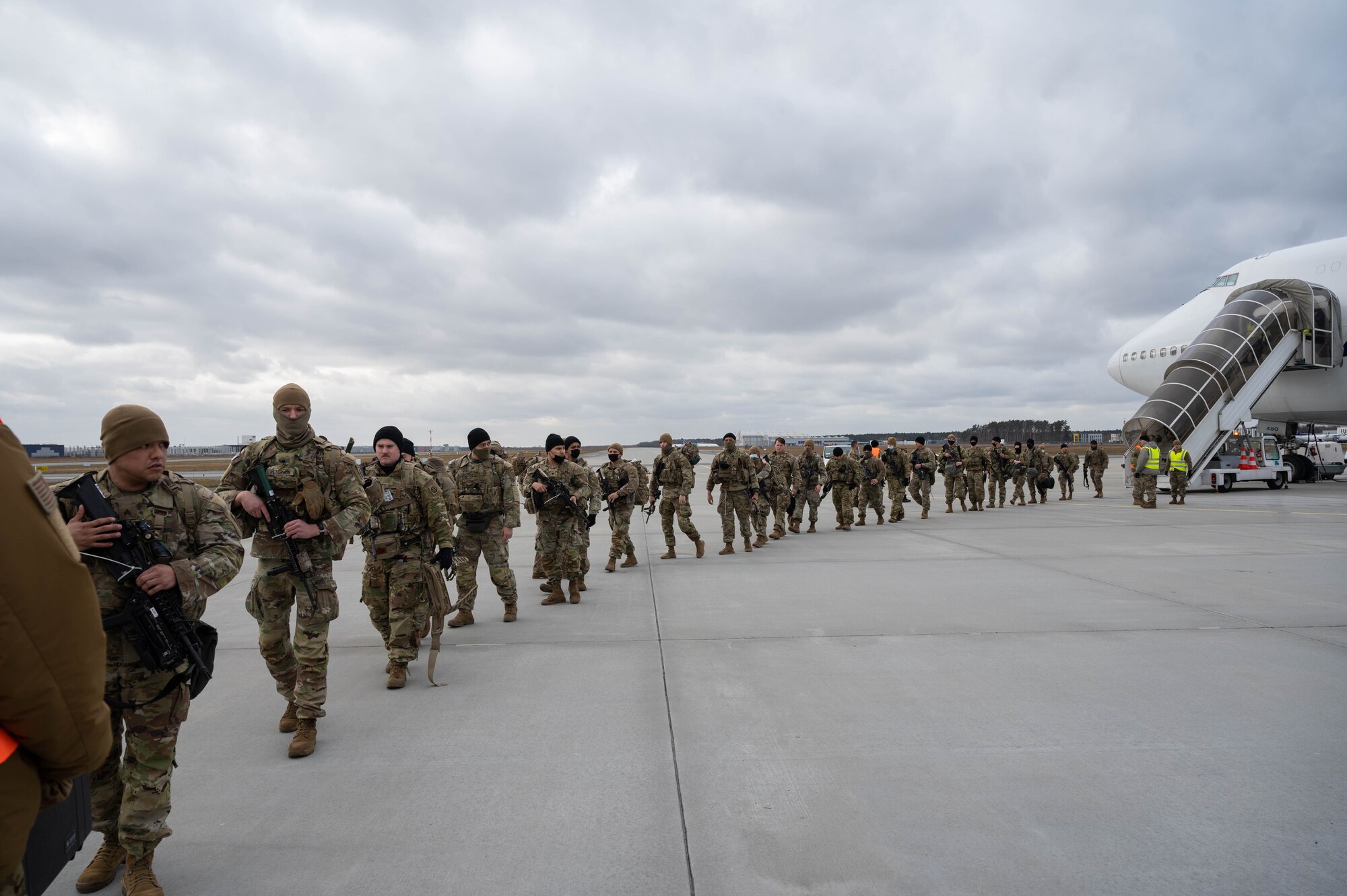 Soldiers depart a Boeing 747 aircraft.