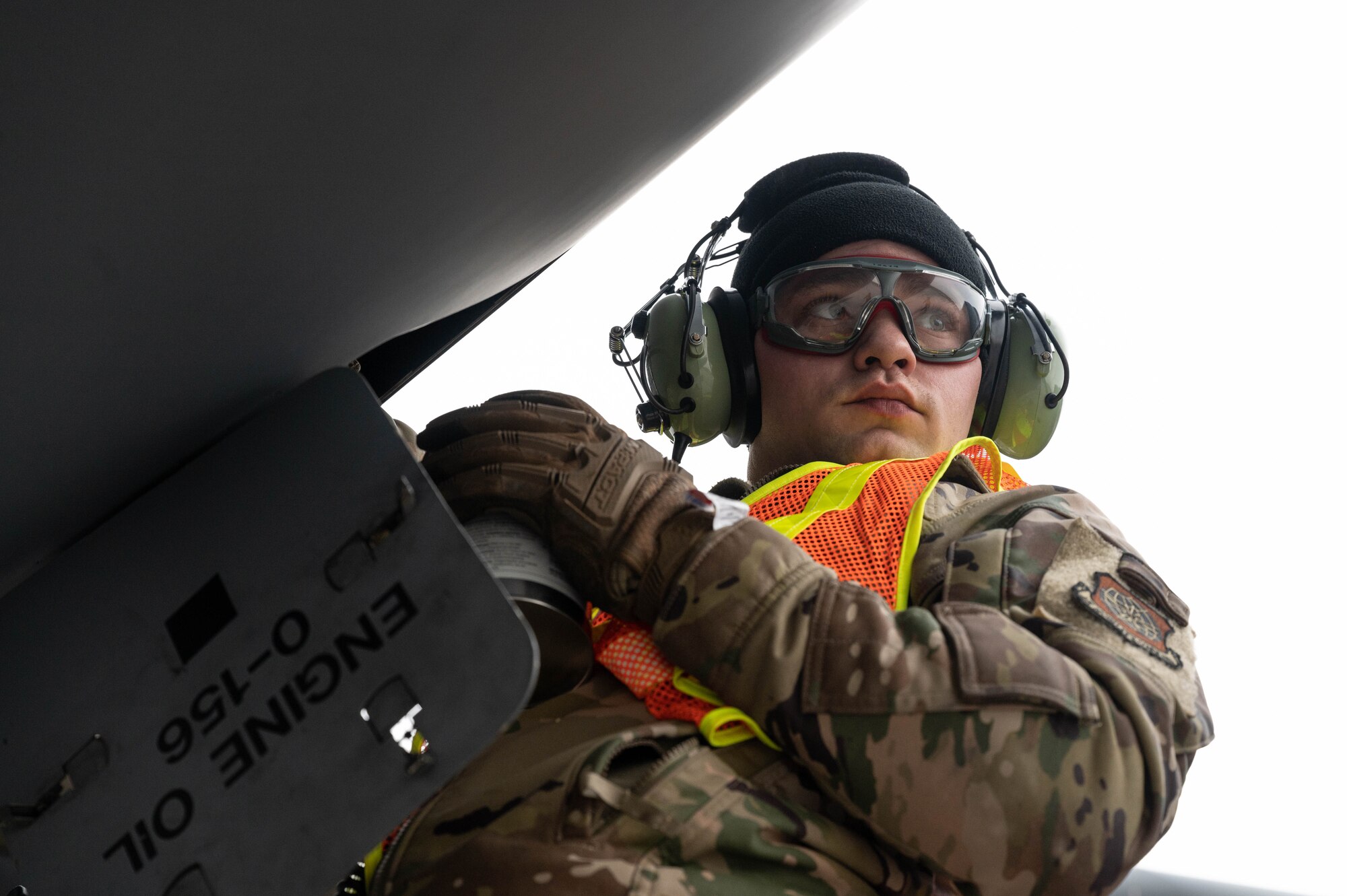 A maintainer pours oil in a C-17 Globemaster III aircraft's engine.