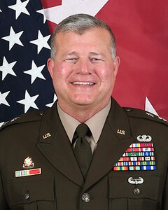 Army General with flag behind him.